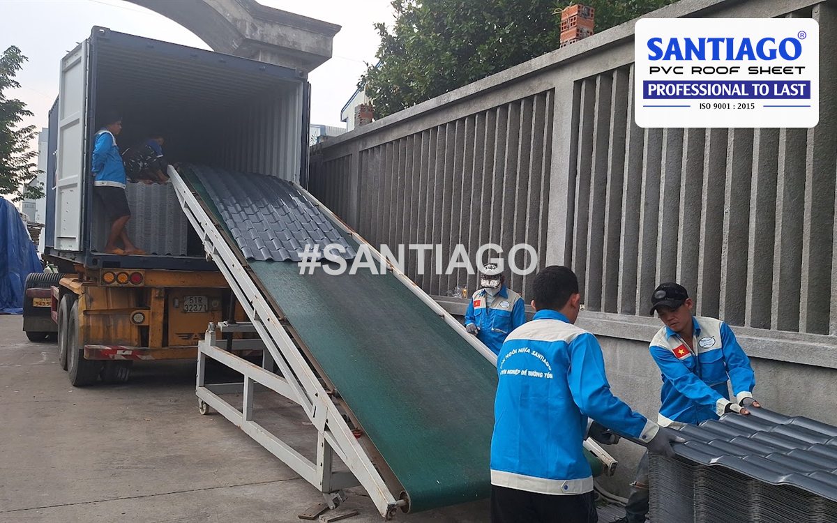 Loading grey ASA/PVC roof tiles into a container by conveyor ramp at the Santiago factory, November 2024