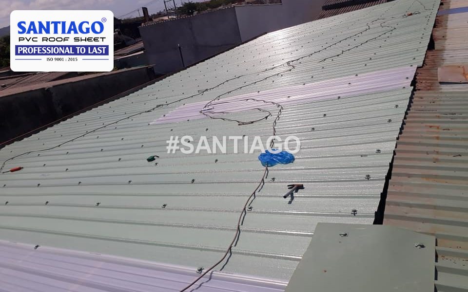 A white skylight sheet being fixed into a green 6-wave roof, seen from above during installation, Vietnam, 2019