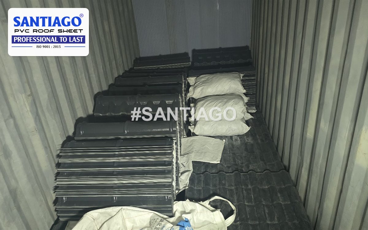 Dark grey roof tiles and bagged accessories packed inside an export container, January 2026